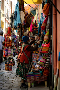 A vibrant Ecuadorian market scene with colorful textiles and smiling vendors.
