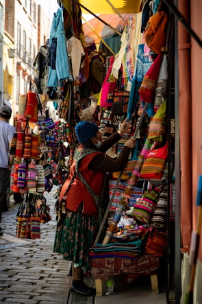 Vibrant market stall displaying colorful Mexican textiles and handmade goods.
