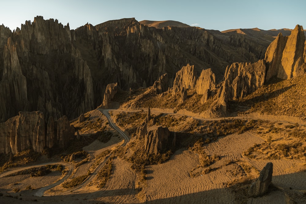 a scenic view of a mountain range with a road winding through it