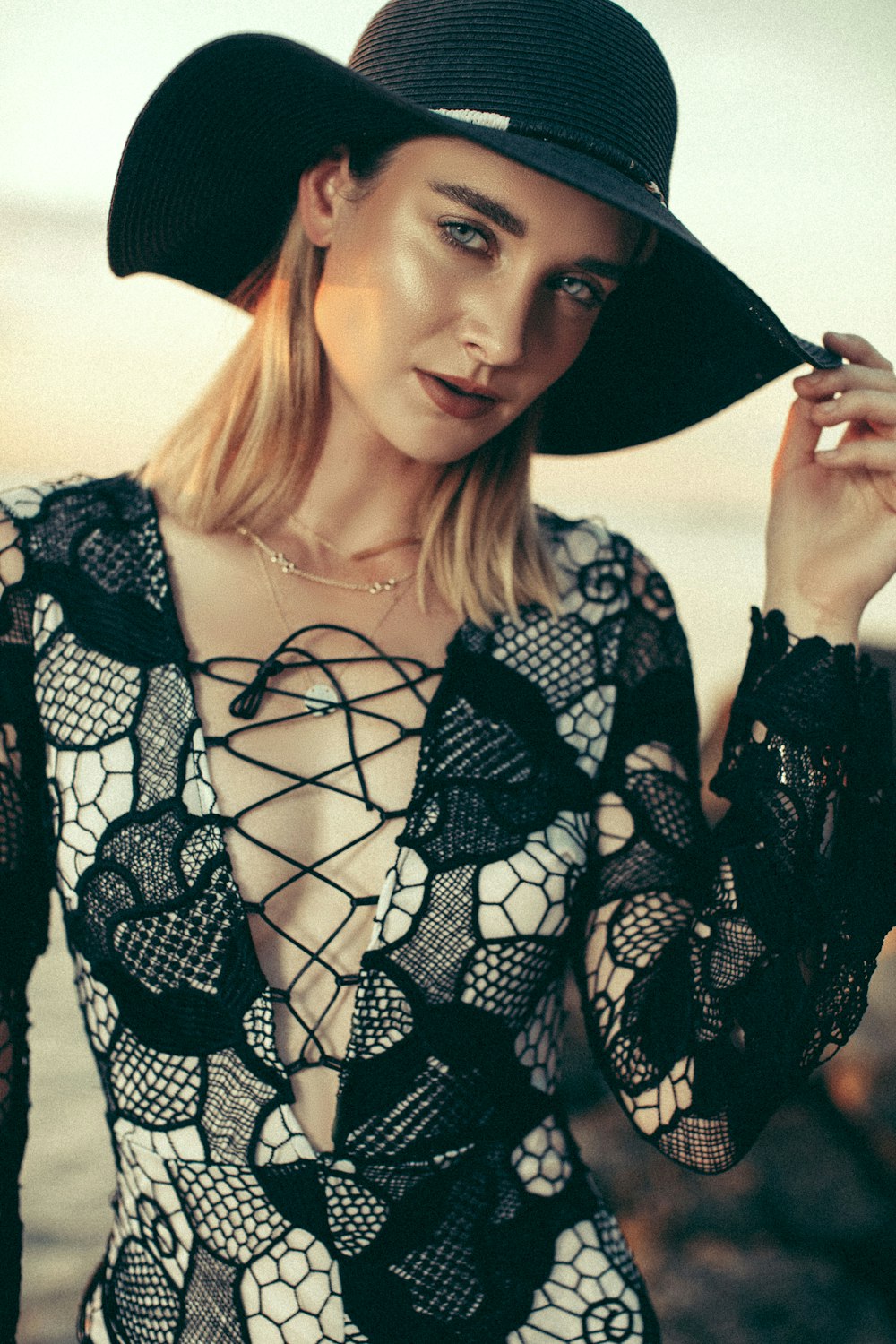 a woman in a black hat is posing for a picture