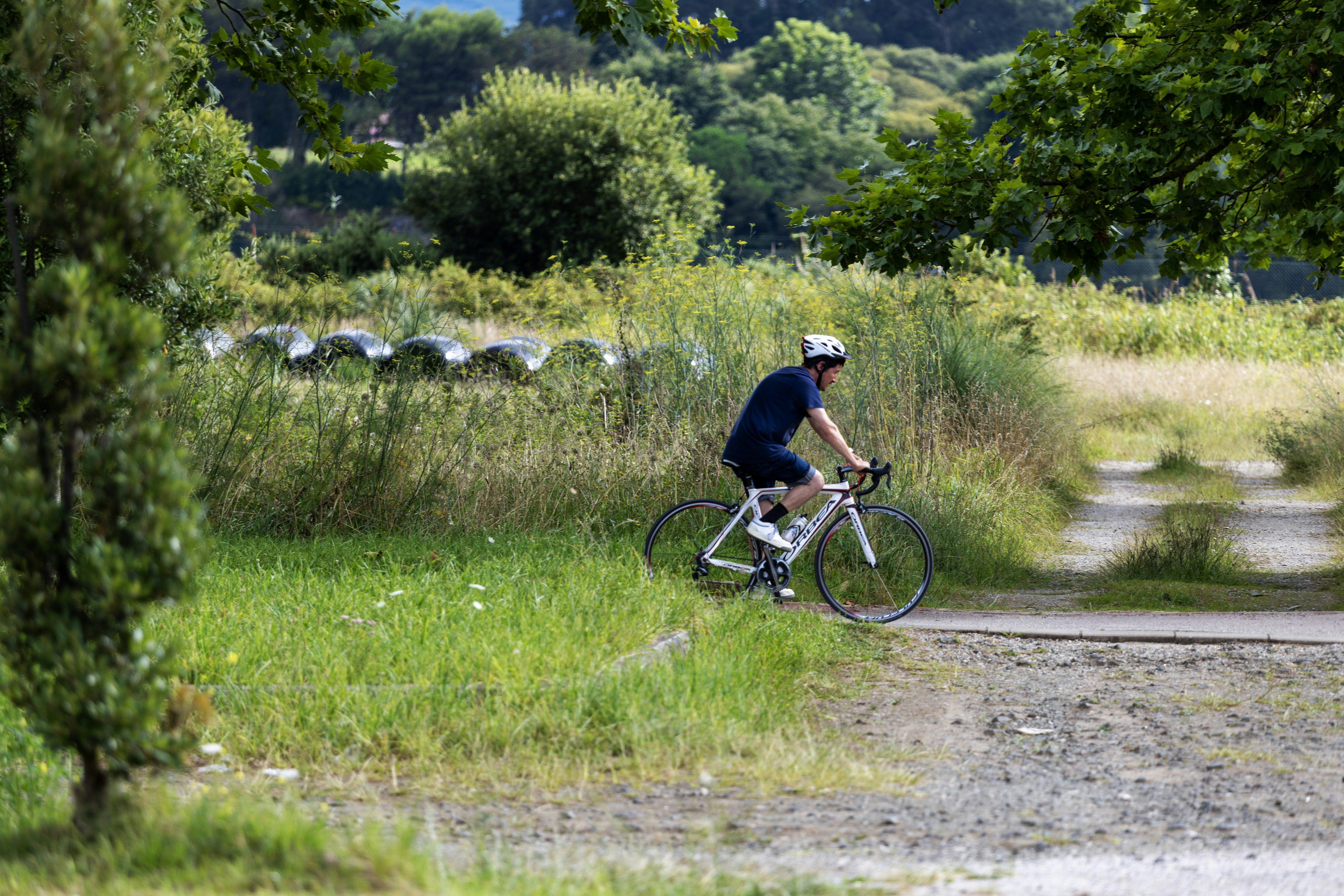 a man riding a bike down a dirt road