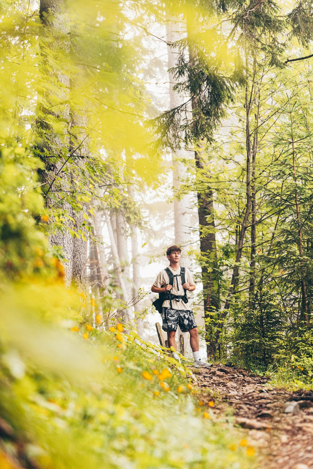 a man walking through a forest with a backpack