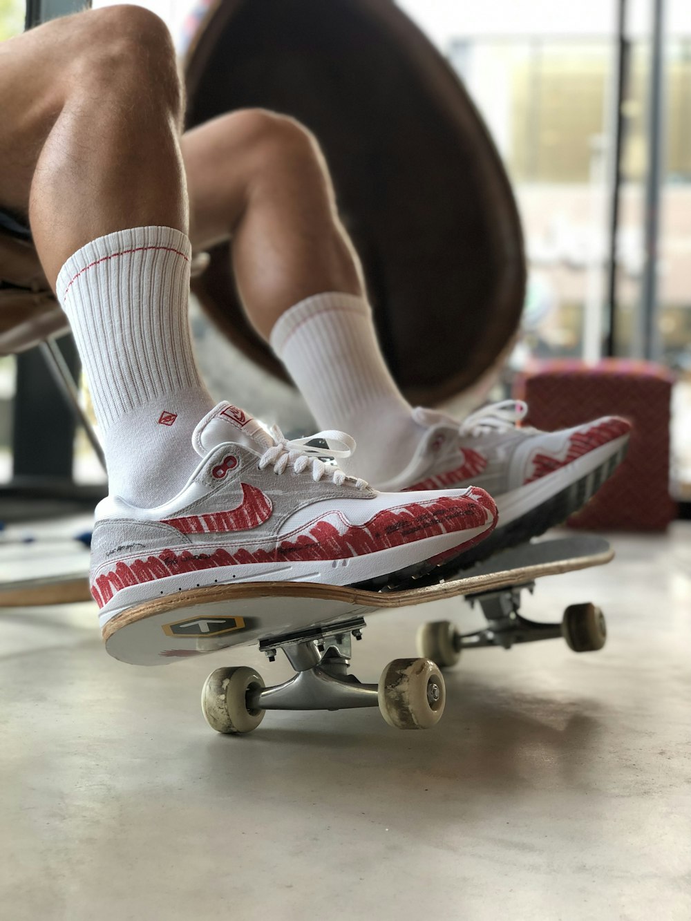 una persona seduta su uno skateboard in una palestra