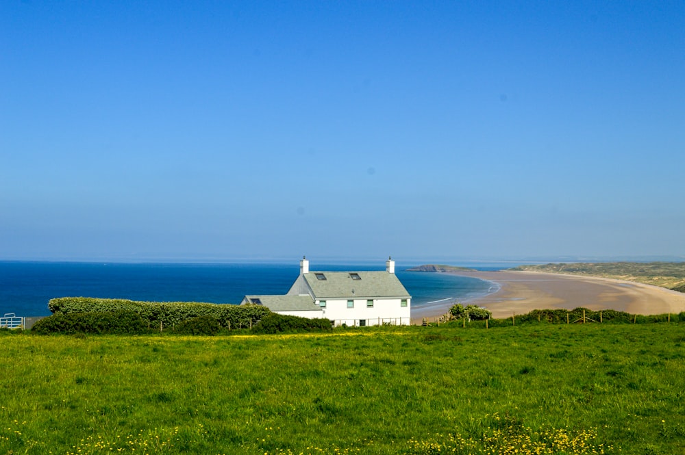 a white house sitting on top of a lush green hillside