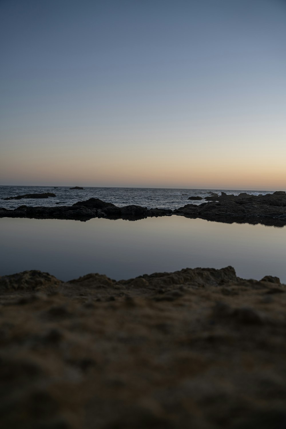 uno specchio d'acqua seduto accanto a una spiaggia sabbiosa