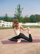 A fit influencer demonstrating a yoga pose outdoors with a serene blue sky background