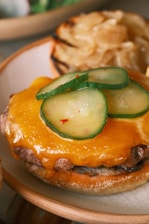 Close-up of a smashed burger with melted cheese and fresh toppings on a toasted bun.