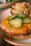 A close-up of a perfectly smashed burger with melted cheese and fresh toppings on a toasted bun.