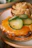 A close-up of a perfectly smashed burger with melted cheese and fresh toppings on a toasted bun.