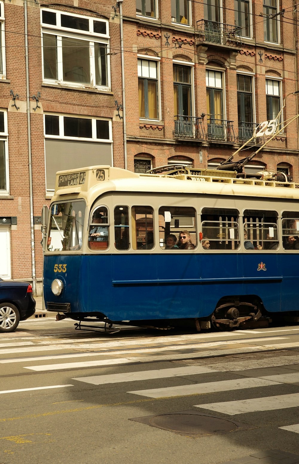 a blue and white trolley on a city street