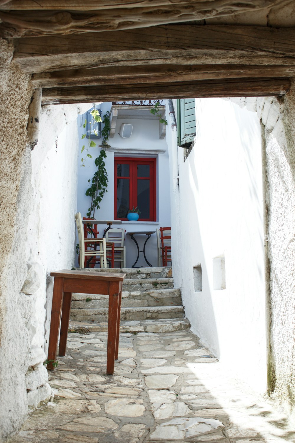 a narrow alley way with a table and chairs