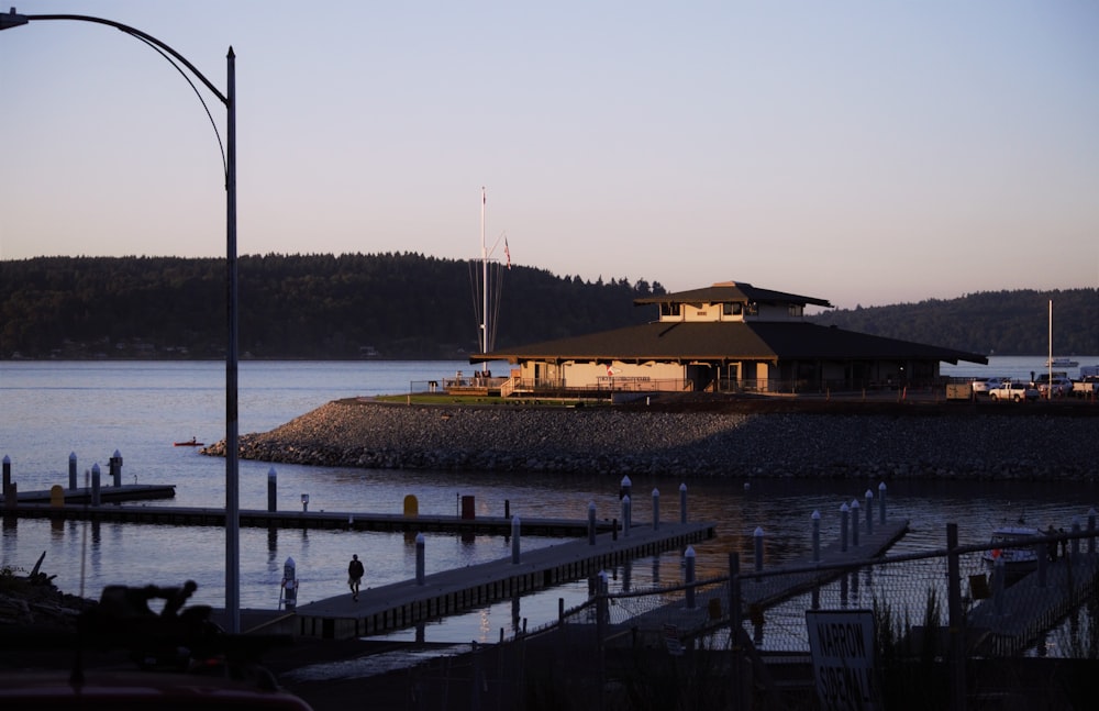 a house sitting on top of a pier next to a body of water