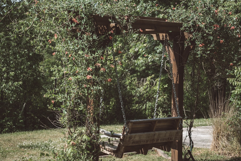 a wooden bench sitting under a wooden arbor