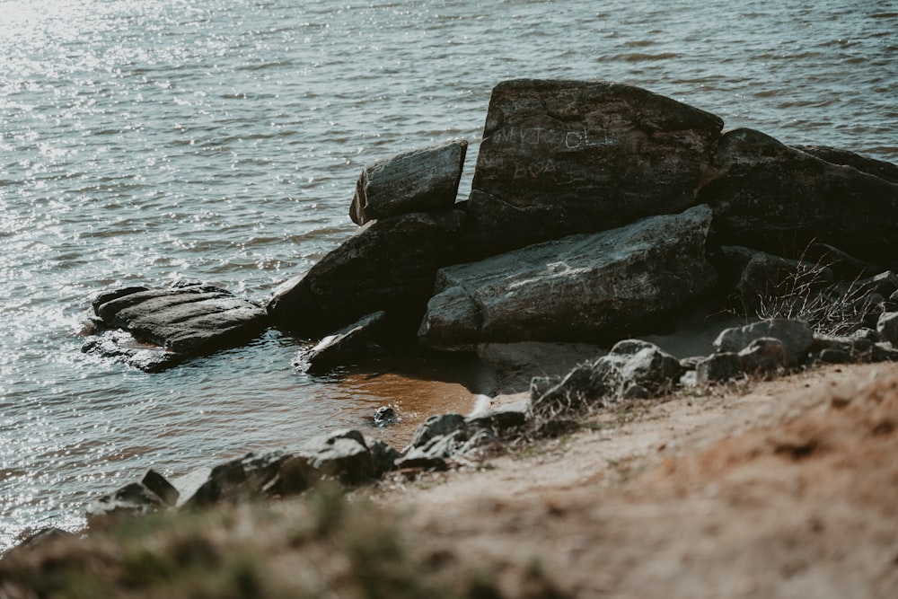 a large rock sitting in the middle of a body of water