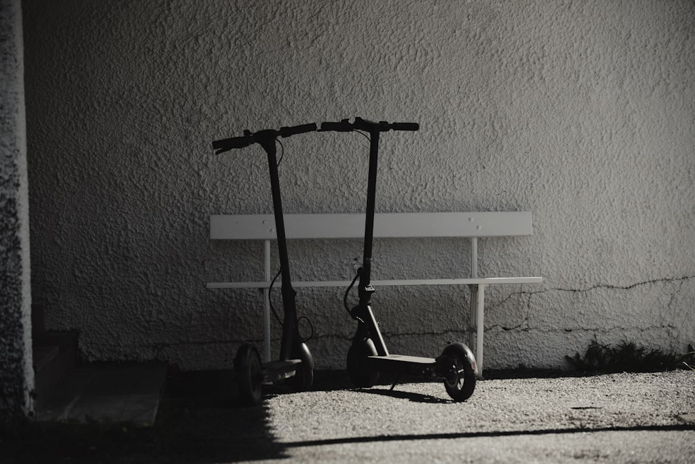 a scooter parked in front of a white bench