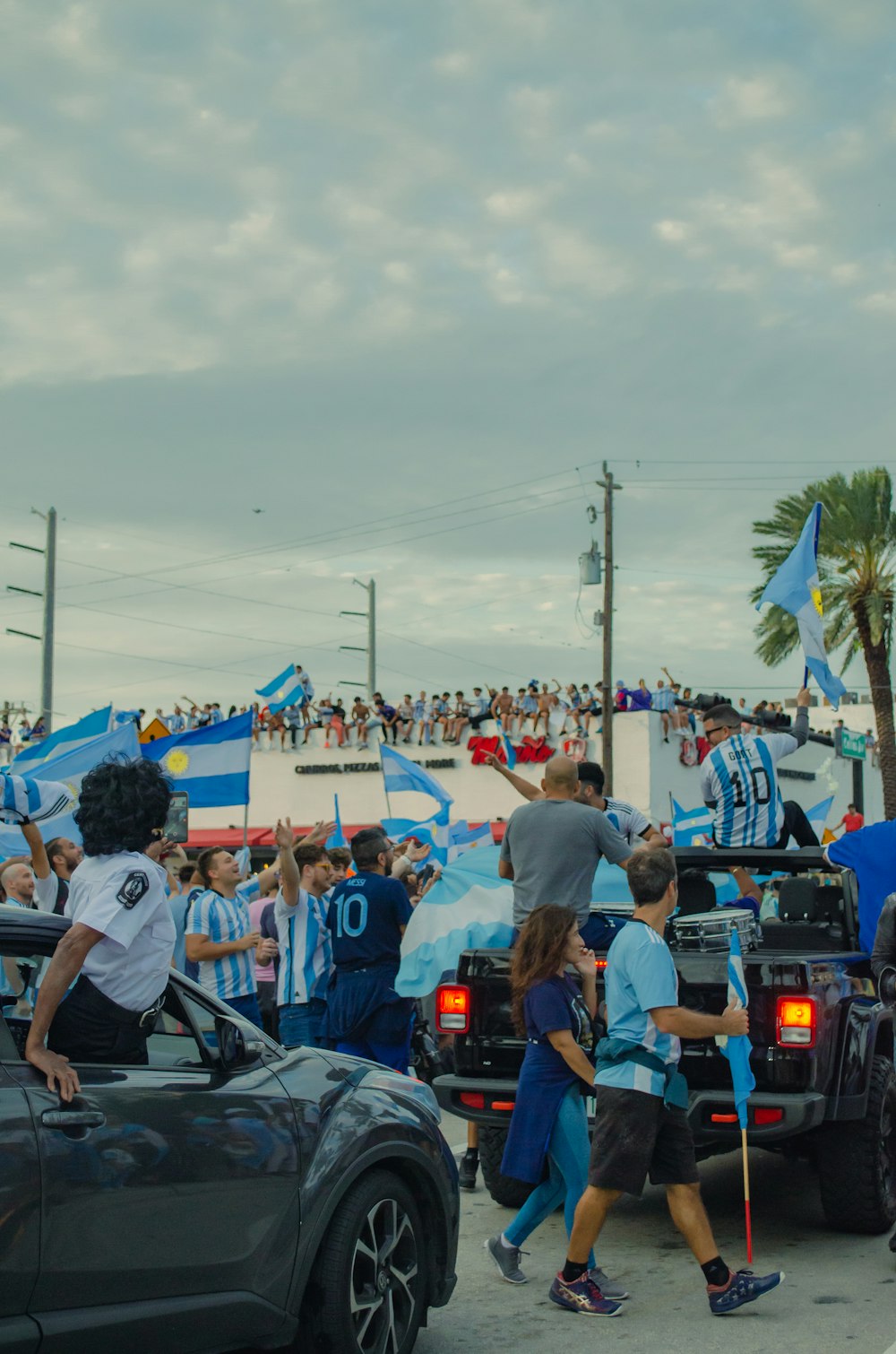 a group of people walking down a street next to a car