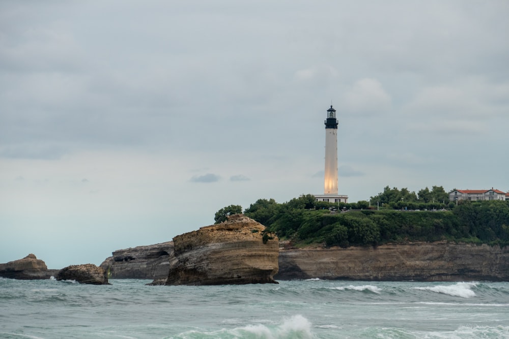 a light house sitting on top of a cliff next to the ocean