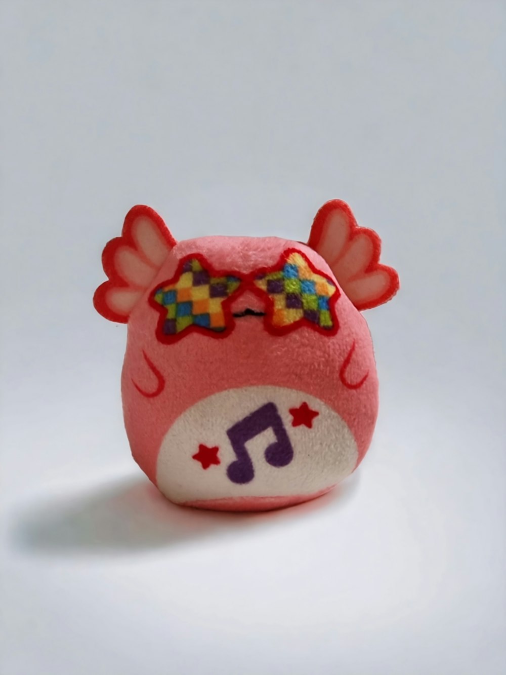 a red stuffed animal with a musical note on it