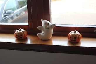 A warmly lit haunted garage entrance decorated with friendly ghost figures and pumpkins
