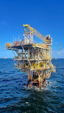 Technician operating hydrographic survey equipment on offshore platform deck