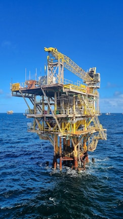 Technicians performing maintenance on offshore equipment under bright daylight.