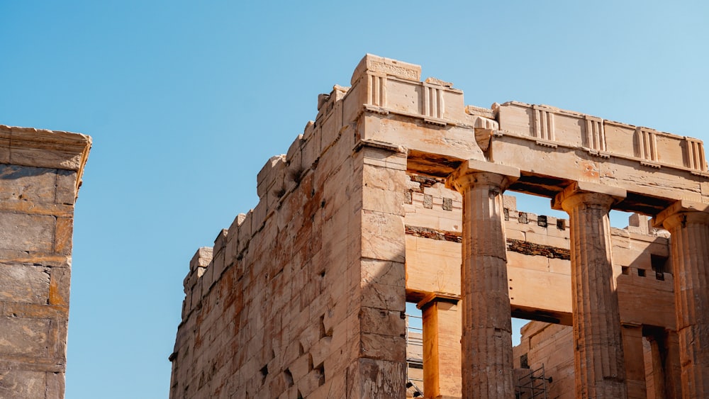 a stone building with two columns and a sky background