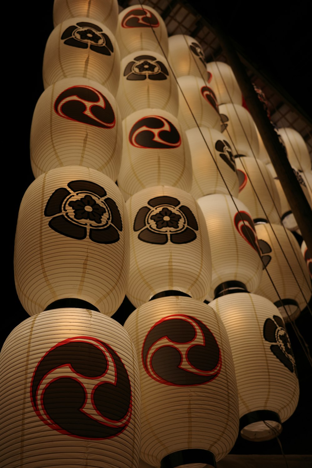 a large number of paper lanterns hanging from a ceiling