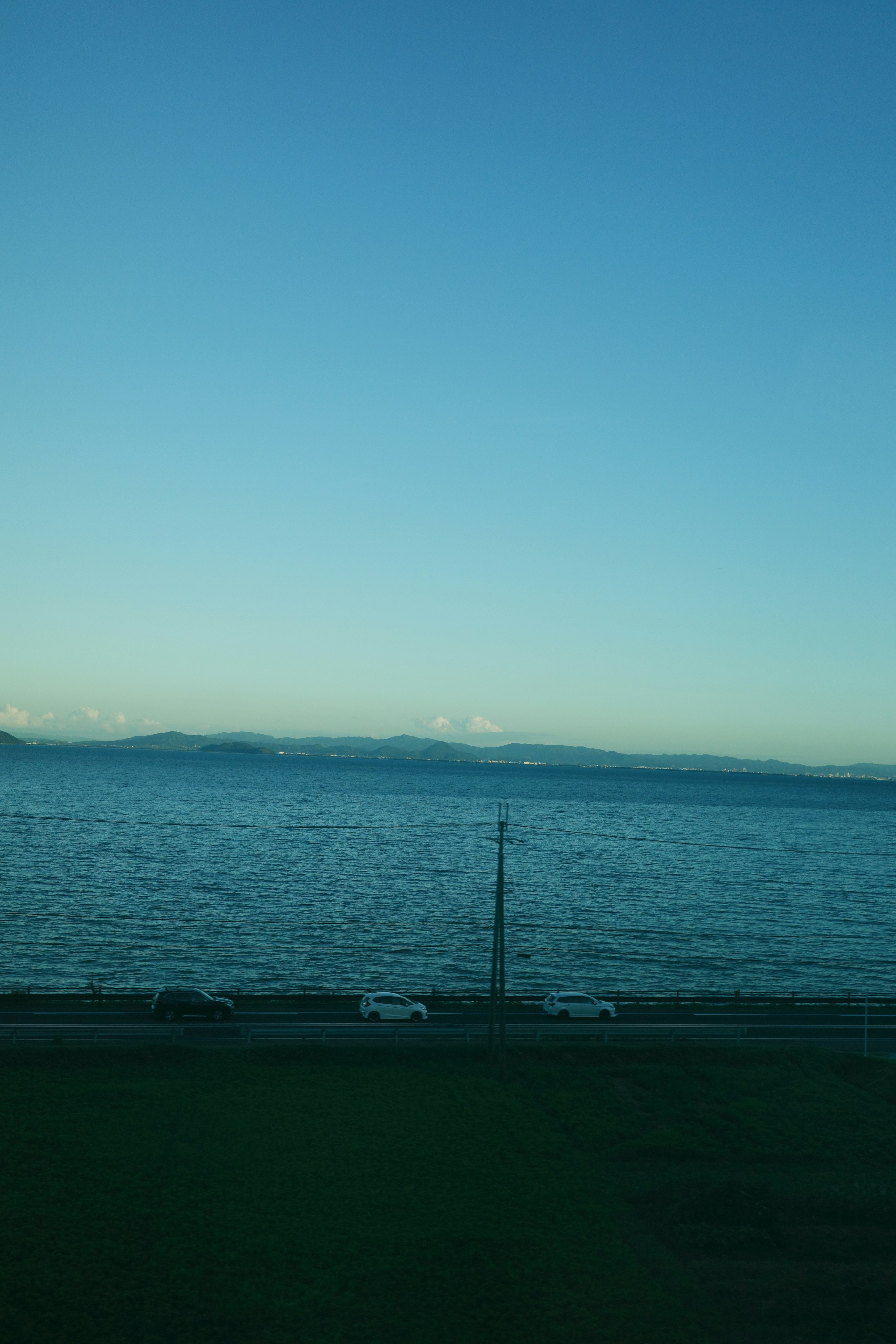 緑豊かな野原の隣に座っている大きな水域