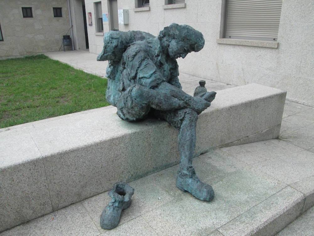 a statue of a man sitting on a stone step