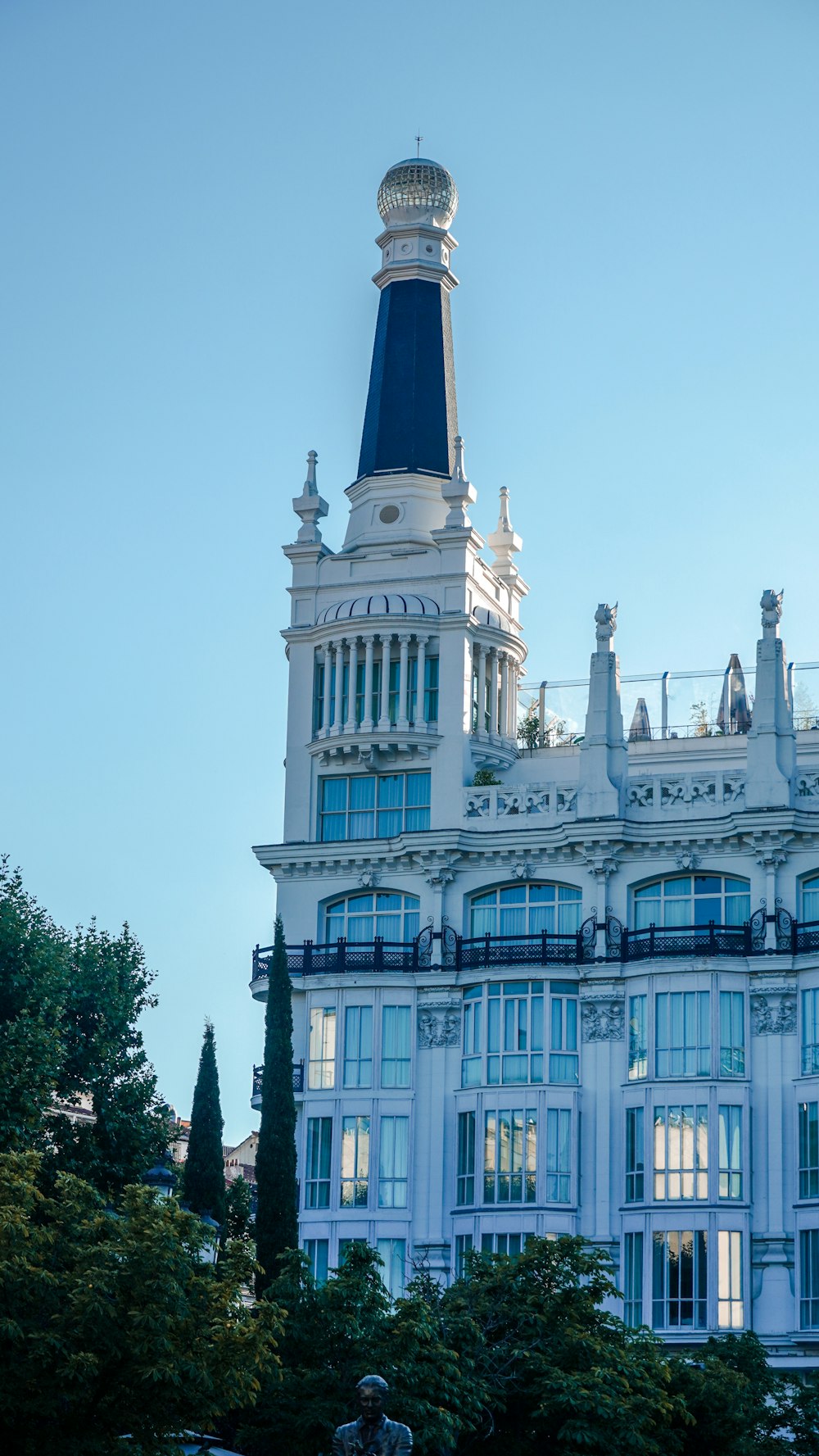 a tall white building with a clock on the top of it