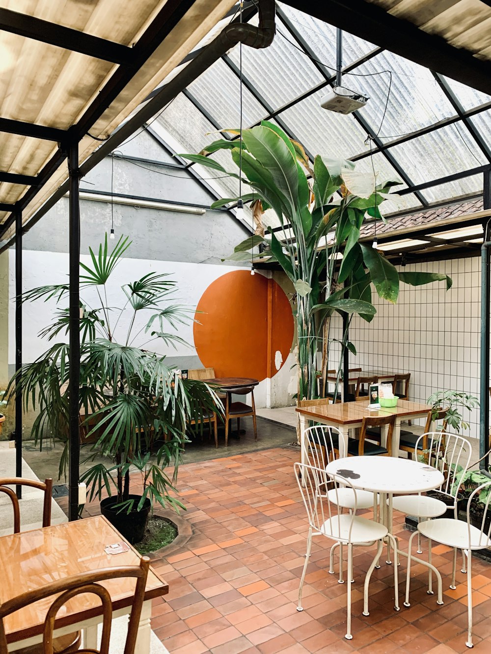 a patio with a table and chairs and a potted plant