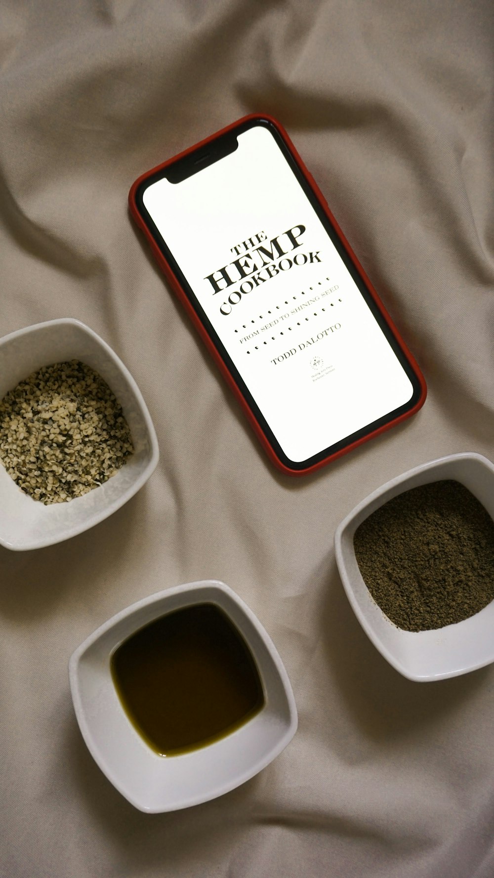 three bowls of spices and a phone on a bed