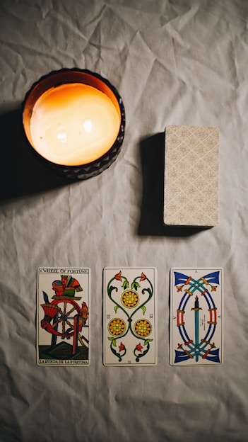 A cozy table with tarot cards spread out, soft candlelight illuminating the scene.