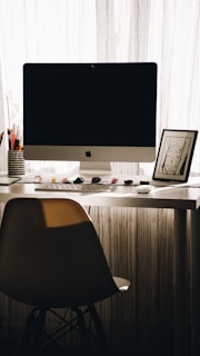 A serene office space with a desk, laptop, and gemstones displayed elegantly.