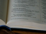 Close-up of an old, leather-bound book open to a chapter with elegant typography.