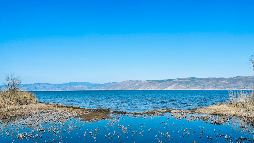 a body of water surrounded by land and mountains