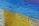 A textured wall surface painted with bold colors, including bright yellow, sky blue, and a hint of purple. The paint appears to be layered, creating distinct geometric patterns across the rough, concrete-like material.