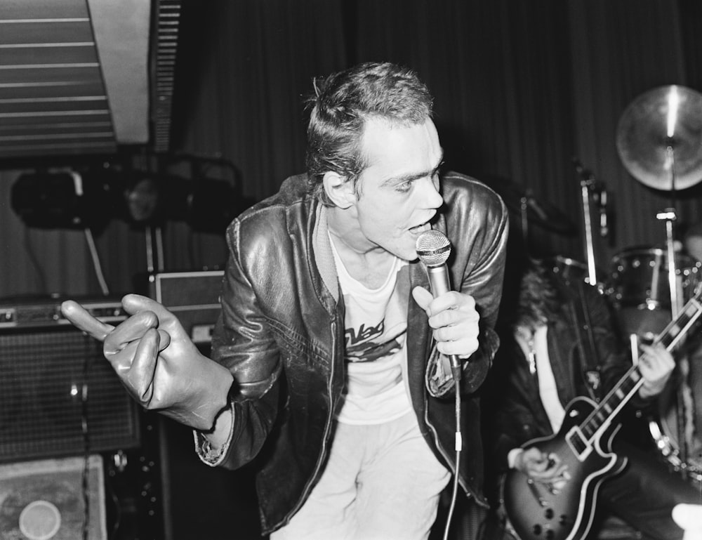 a black and white photo of a man singing into a microphone