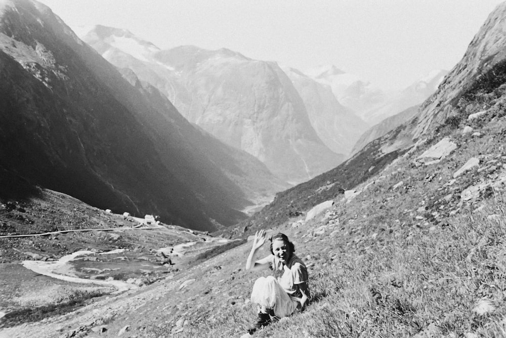 a woman sitting on the side of a mountain