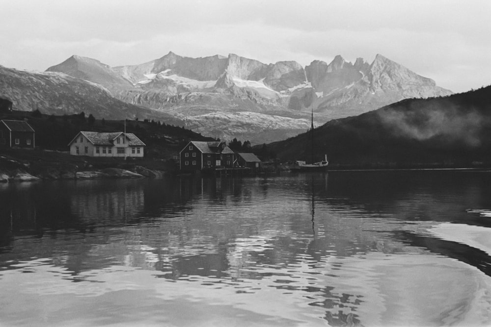 a black and white photo of a lake and mountains