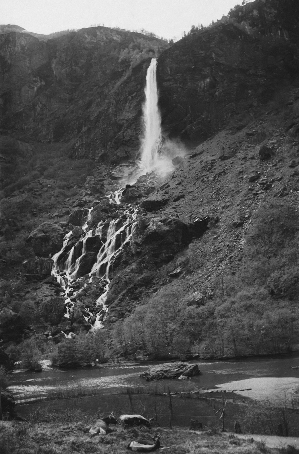 an old photo of a waterfall in the mountains