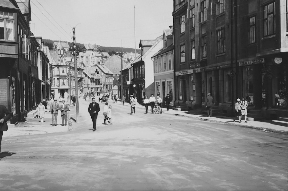 a black and white photo of people walking down a street