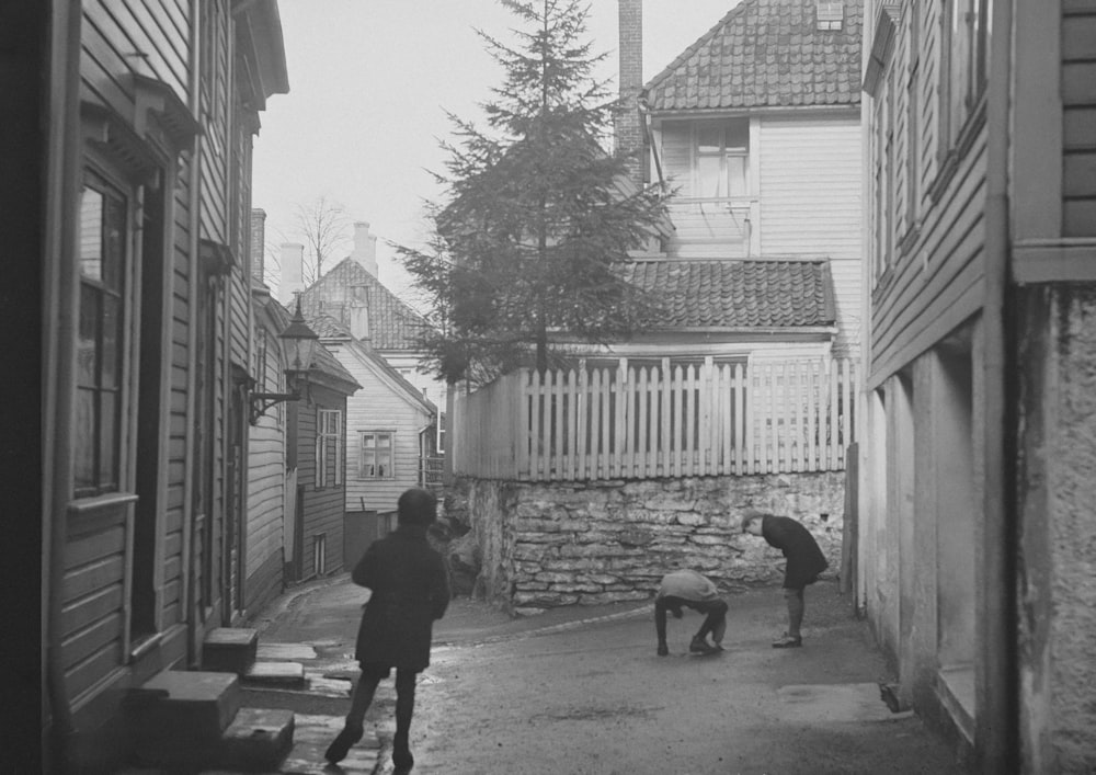 a black and white photo of people walking down a street