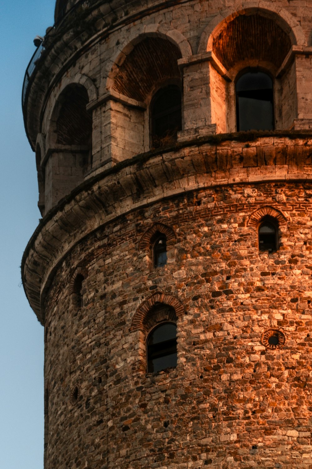 a very tall brick tower with a clock on it's side