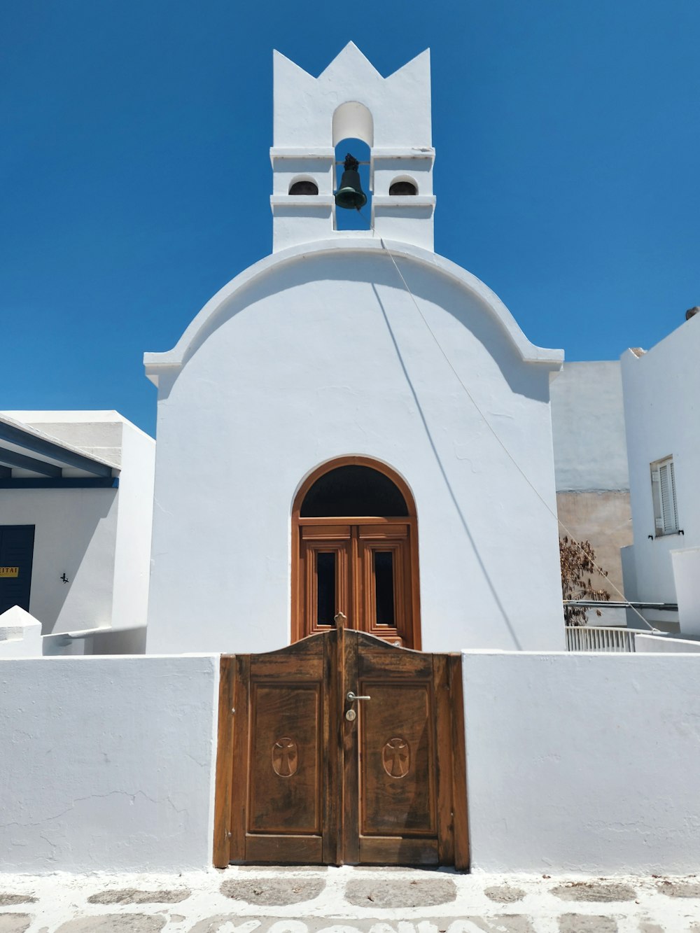 a white building with two doors and a bell tower