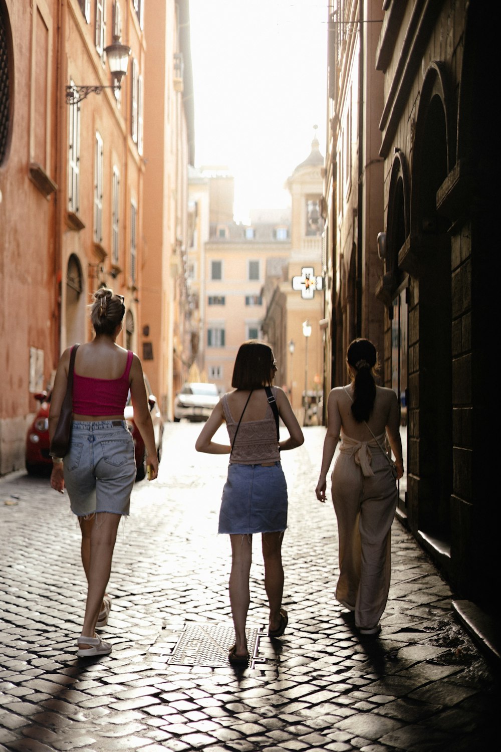 three women walking down a cobblestone street