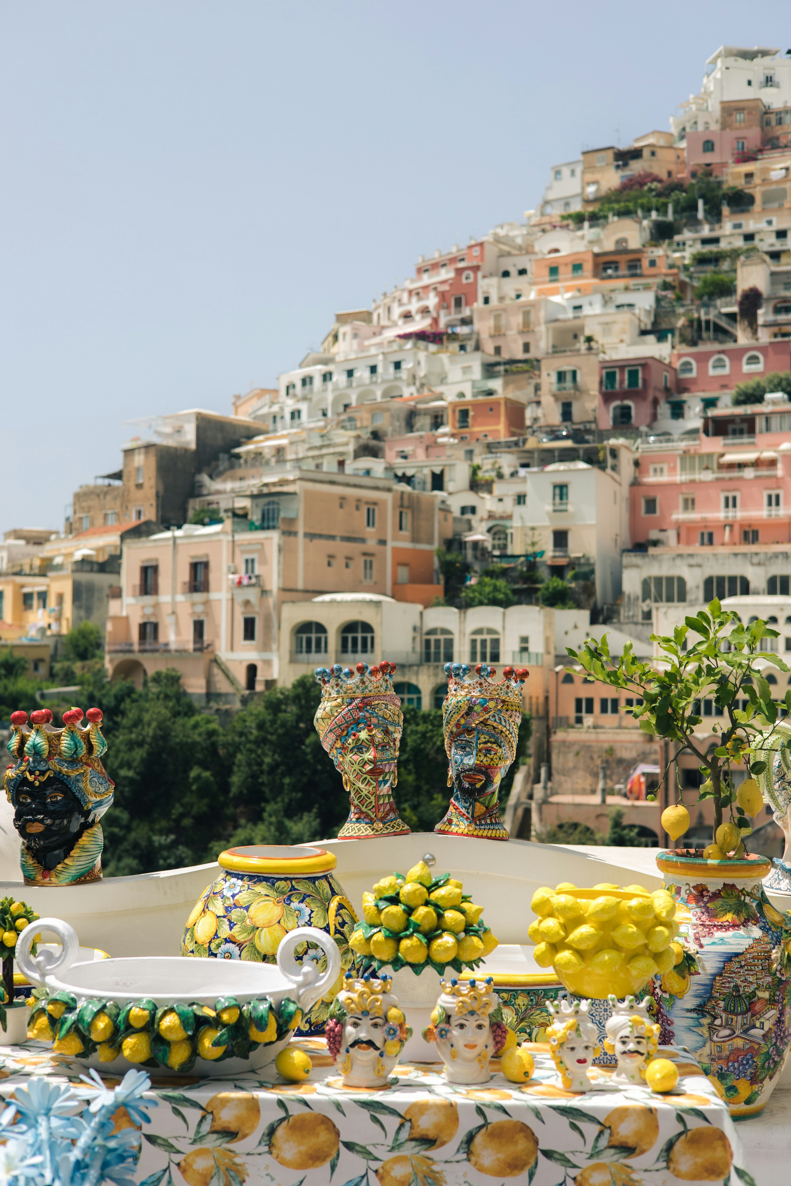Hand-painted Amalfi Coast ceramics and limoncello bottles in a lemon grove