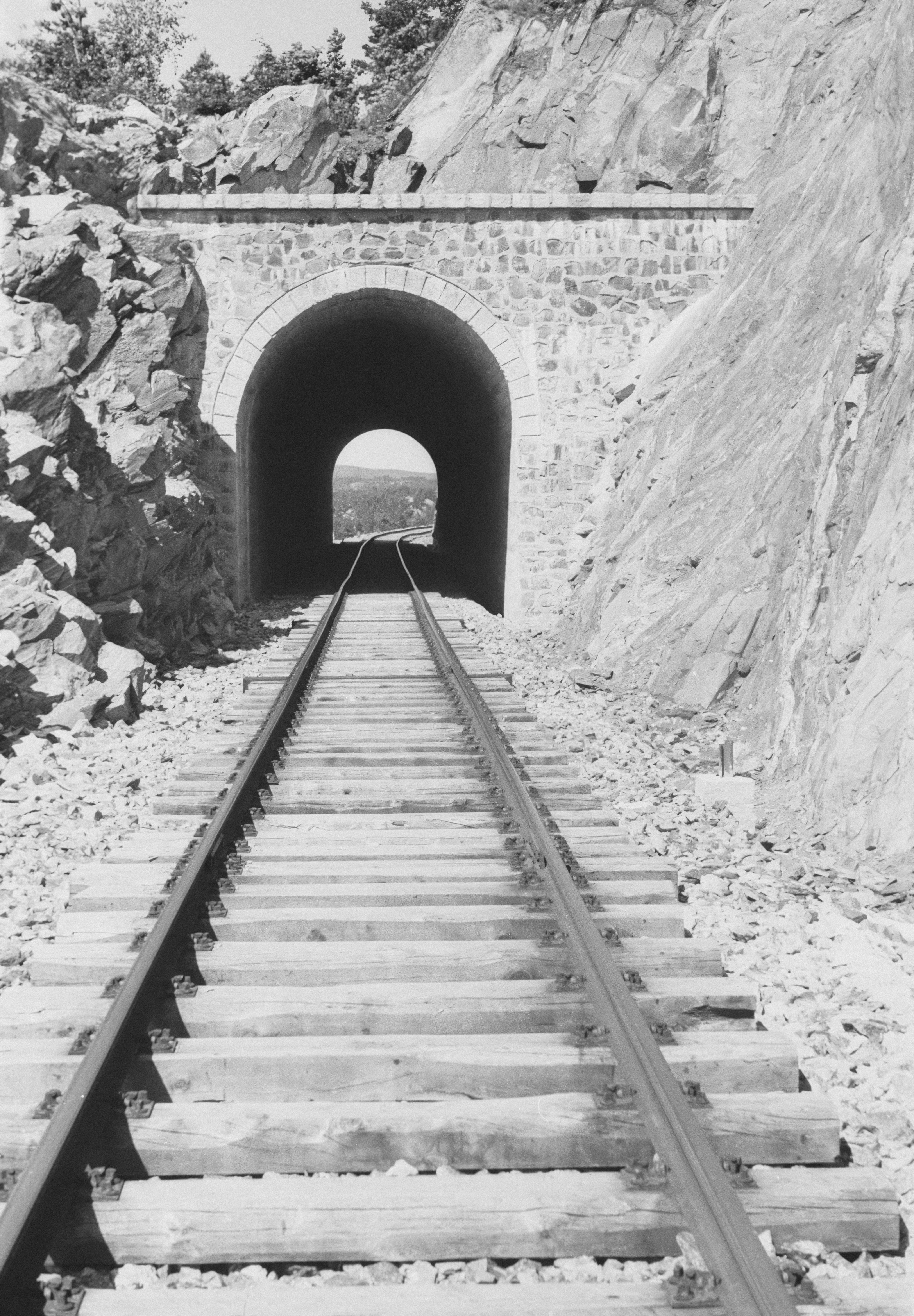 ein Schwarz-Weiß-Foto eines Zuges, der aus einem Tunnel kommt