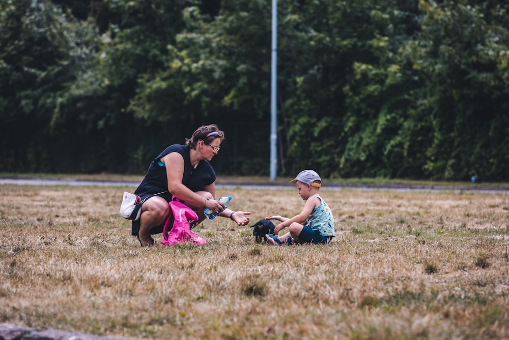 a woman kneeling down next to a small child