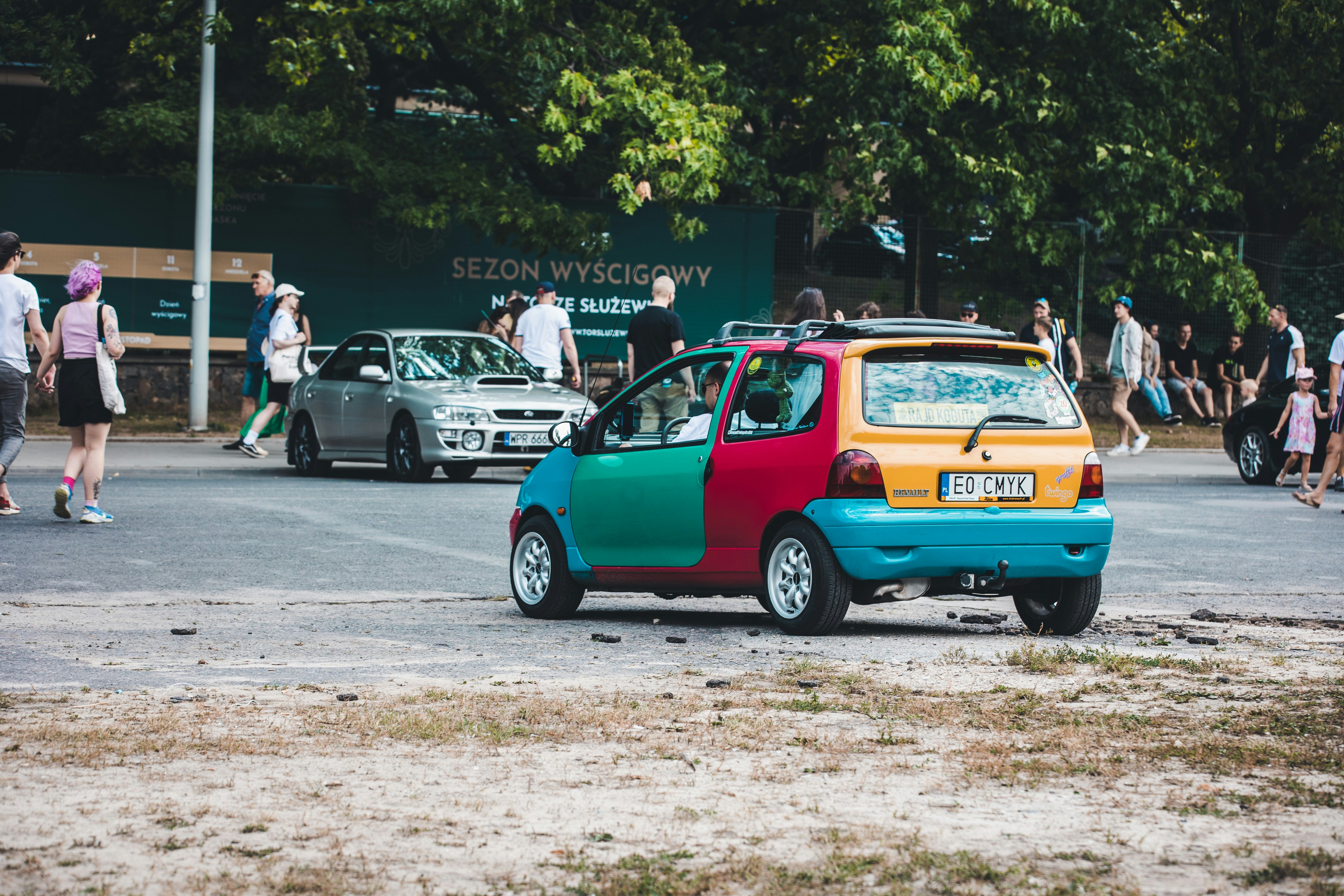 a small colorful car parked in a parking lot